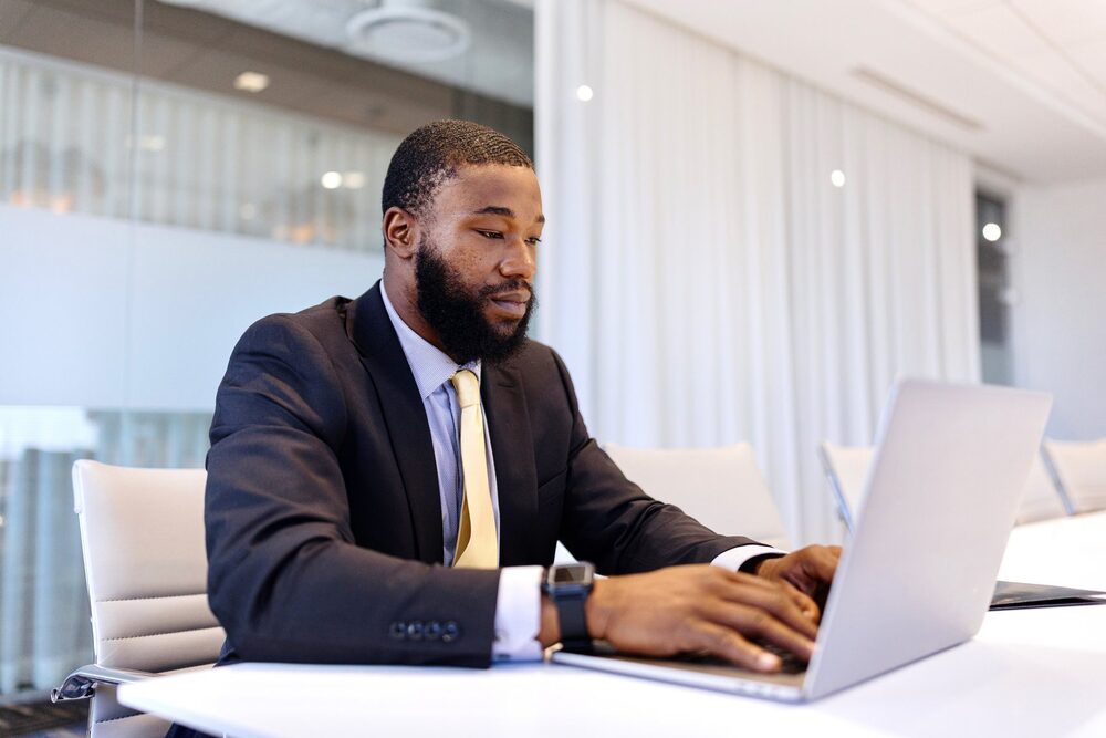 A jobseeker writing an accomplishment story at a laptop